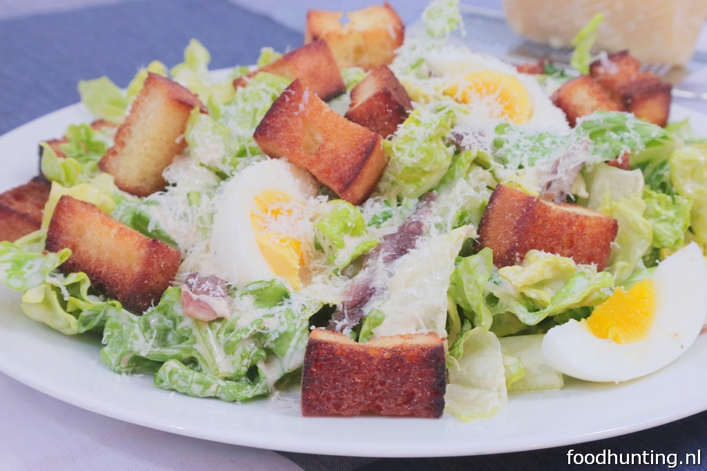 Caesar salade met zelfgebakken croutons, ei, ansjovis en Parmezaanse kaas